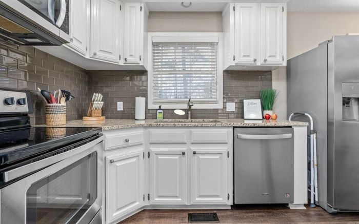 Updated kitchen with stainless appliances and white cabinetry