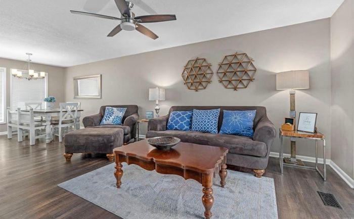 Living space with plush seating open to sunlit dining room