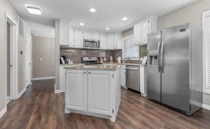 Full kitchen with island and stainless refrigerator